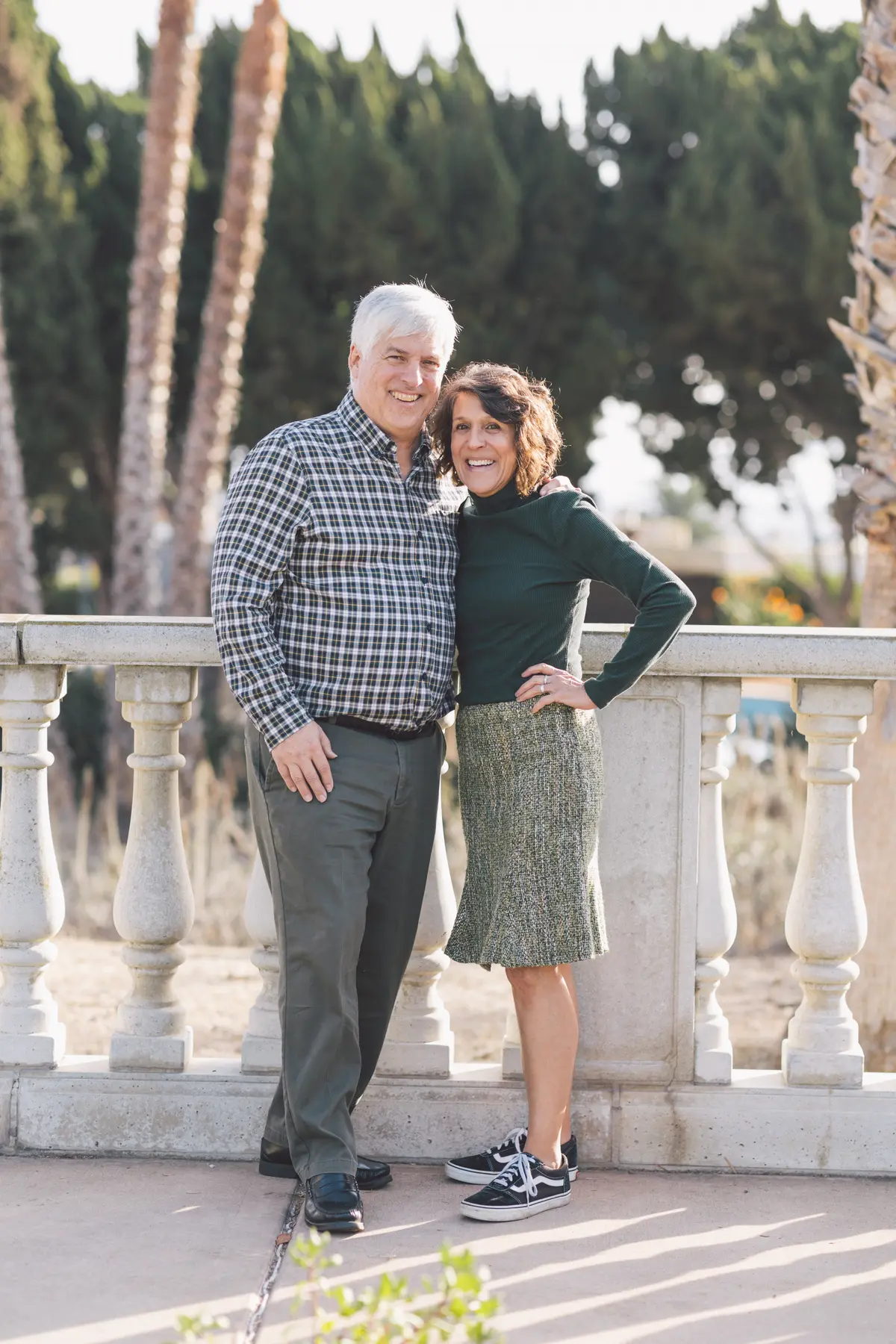 Couple smiling arm in arm on a sunny terrace