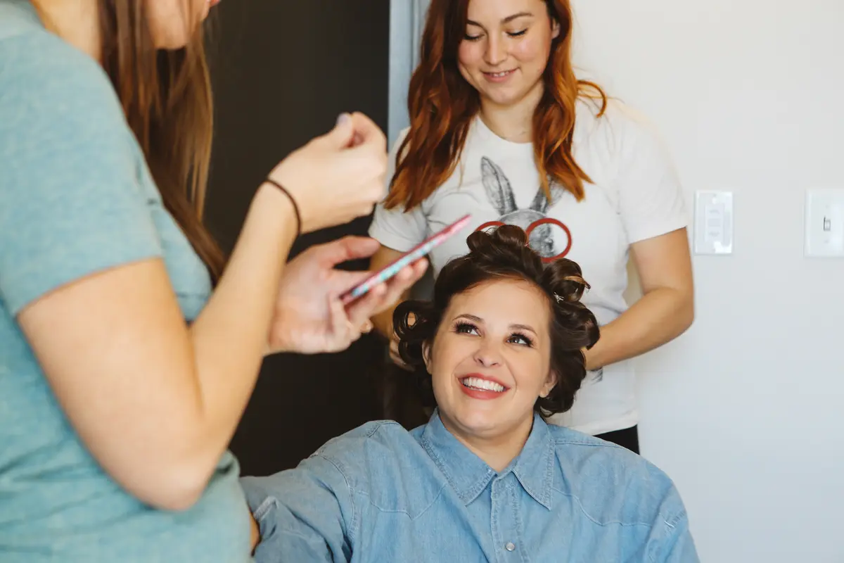 Bride smiling while her hair is curled on the wedding morning