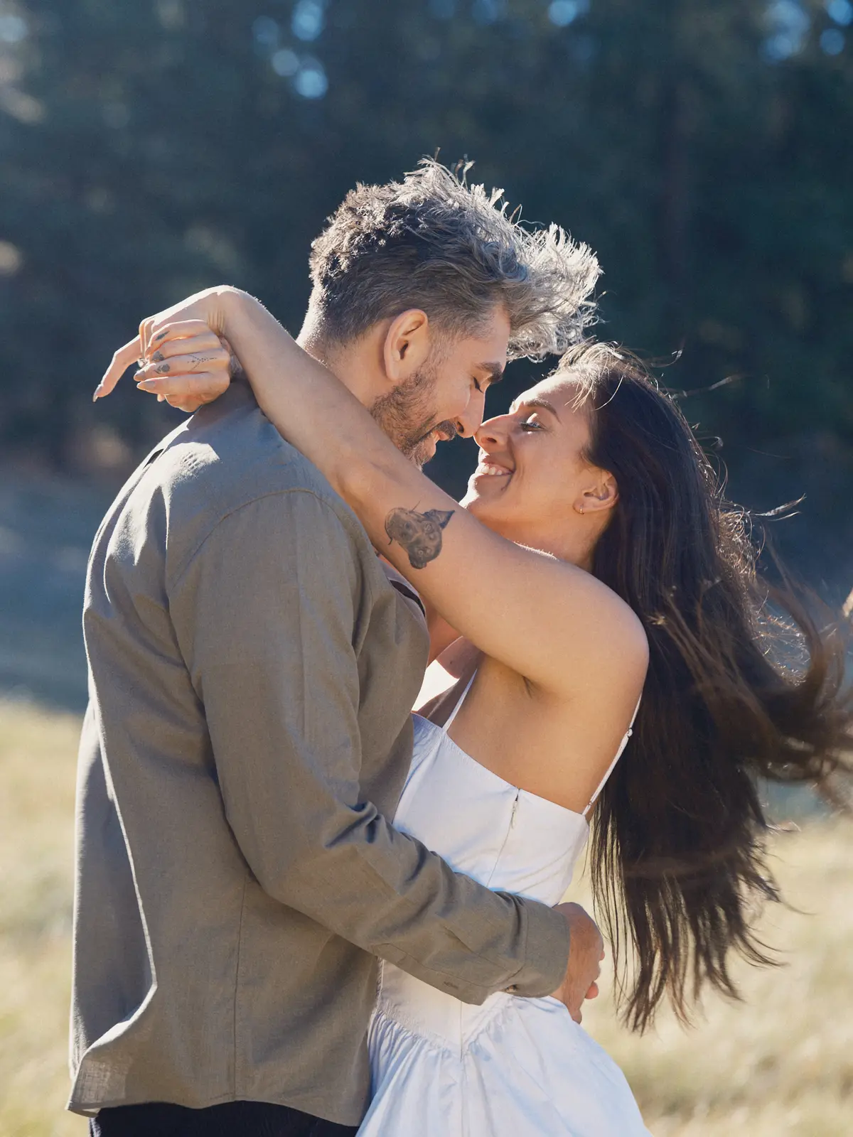 Couple embracing nose to nose in warm evening light