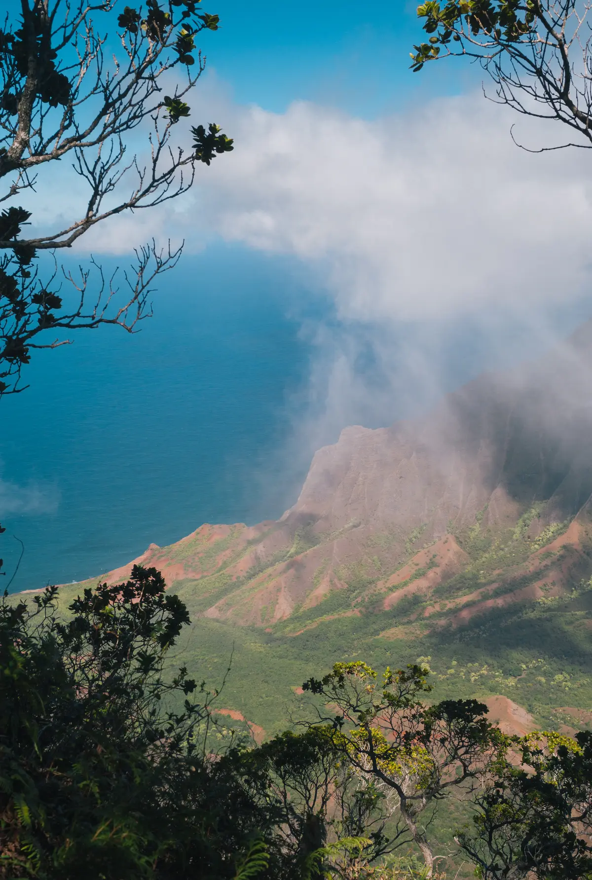 Clouds drifting over the green cliffs of Kalalau Valley and the ocean on Kauai’s Nā Pali Coast