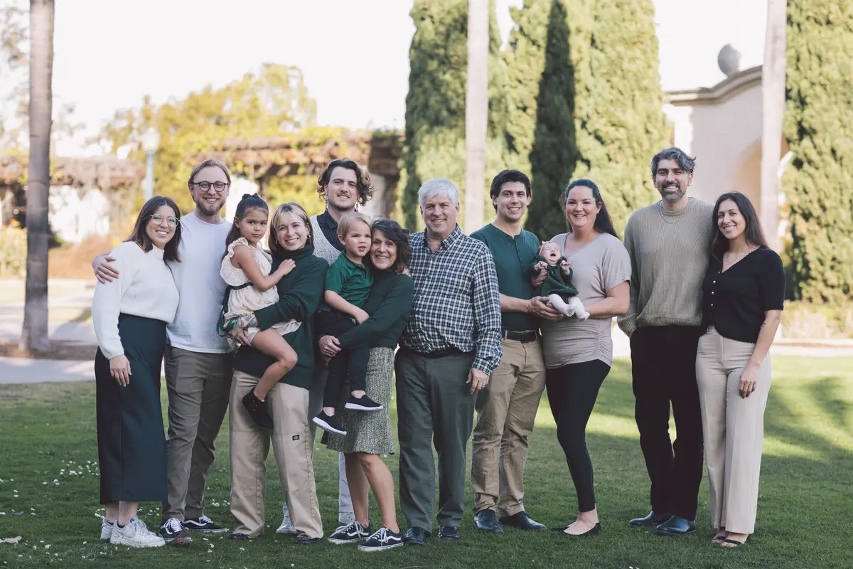 Multi-generational family portrait on a garden lawn at a birthday celebration
