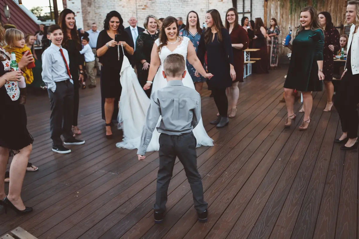 Kids and guests on the dance floor around the bride at the reception